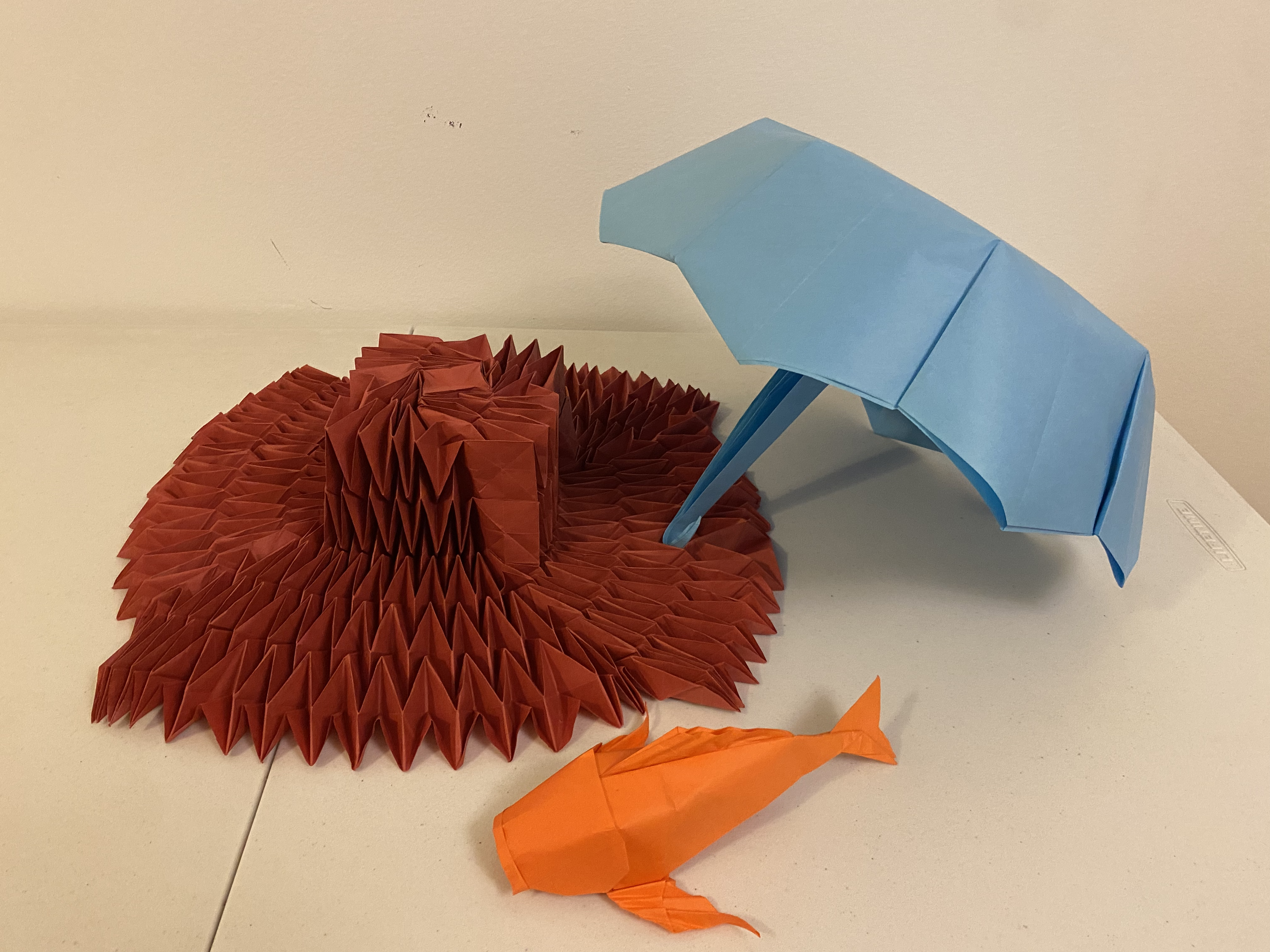 An origami flasher hat, an origami umbrella, and an origami koi.